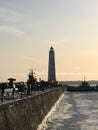 Lighthouse and pier at sunset in the city of Kronstadt in winter.