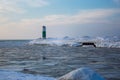 Lighthouse on pier in winter during sunset