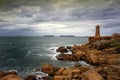 Ploumanac`h Mean Ruz lighthouse between the rocks in pink granite coast, Perros Guirec, Brittany, France. Royalty Free Stock Photo