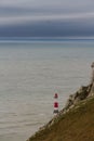 Lighthouse red and white striped on stormy winter day.