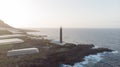 Lighthouse in a rocky cliff and banana tree around on the atlantic ocean. Coastline in the sunset. Light orientation to navigate