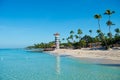 Lighthouse on a sandy tropical island with palm trees. Royalty Free Stock Photo