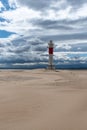 Lighthouse by the sea in the middle of the desert. Brown, blue and gray colors Royalty Free Stock Photo