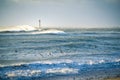 Lighthouse in the sea during windstorm with seagulls