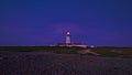 Lighthouse sending its light beam at night, cape Espichel, Portugal