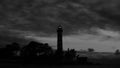 Lighthouse shines in the dark with a dramatic sky. silhouette of glowing beacon in darkness Royalty Free Stock Photo