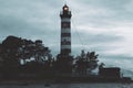 Lighthouse shines near the shore at sunset Royalty Free Stock Photo