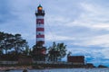 Lighthouse shines near the shore at sunset Royalty Free Stock Photo