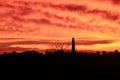 Lighthouse silhouette over purple dawn sky