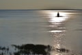 Lighthouse silhouette at sunset on St-Lawrence River. Peaceful and solitude moment.