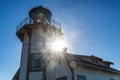 Lighthouse silhoutted with sun stars