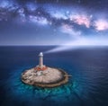 Lighthouse on smal island in the sea and Milky Way at night Royalty Free Stock Photo