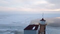 Lighthouse at the source of the Angara river from lake Baikal. Sunset in frosty Siberia in spring