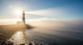 A lighthouse stands on a rocky coastline, enveloped in mist. The structure has red and white Royalty Free Stock Photo