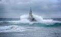 Lighthouse and storm in the sea and large waves that break into the sea light at the port of Ahtopol, Black Sea, Bulgaria