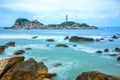 Lighthouse with surf patted smoother reefs create clouds on the sea Royalty Free Stock Photo