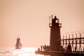 Lighthouse and tall ship at sunset Royalty Free Stock Photo