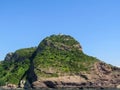 Lighthouse on the top of a greenish mountain