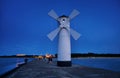 Lighthouse with tourists on the Baltic Sea with windmill wings in SwinemÃÂ¼nde. Swinoujscie, Poland