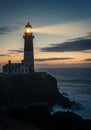 A lighthouse tower stands on a rugged cliff\'s edge overlooking the ocean at sunset. Royalty Free Stock Photo