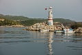 Lighthouse with turkish flag at the entrance to a harbor, city of Kas