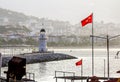 Lighthouse and Turkish flags in the Harbor in Alanya in Turkey at dawn