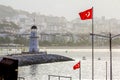 Lighthouse and Turkish flags in the Harbor in Alanya in Turkey at dawn