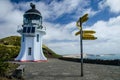 Lighthouse view with signpost from Cape Reinga with blue sky and white clouds above, Northland, New Zealand Royalty Free Stock Photo