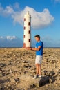 Lighthouse and man at rocky coast