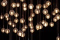 lighting balls on the chandelier in the lamplight, light bulbs hanging from the ceiling, lamps on the dark background, selective Royalty Free Stock Photo