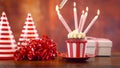 Lighting birthday cupcake with candles and gift