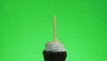 Lighting a blue candle on a delicious cupcake, green screen