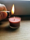 Lighting candle with a lighter. Hand holding lighter with flame. Royalty Free Stock Photo