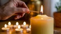 Lighting a candle with a matchstick surrounded by tea light candles Royalty Free Stock Photo