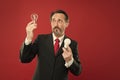 Lighting choices to save money. Man bearded consultant formal suit hold light bulb on red background. Symbol of idea Royalty Free Stock Photo