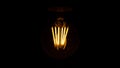 Lighting decor. Retro light bulb. Old dirty lamp dimly lit for Halloween. Selective focus. Royalty Free Stock Photo