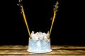 Lighting firework candle, sparkler in creamy cake with marshmallow,snowflakes,skier, sweet dessert