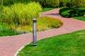 Lighting ground lamp street mounted on a green lawn in a park. Royalty Free Stock Photo