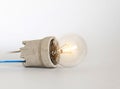 Lighting incandescent lamp bulb with cap, socket, wires lies on white background, new idea concept Royalty Free Stock Photo