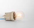 Lighting incandescent lamp bulb with cap, socket, wires lies on white background, new idea concept Royalty Free Stock Photo