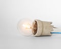Lighting incandescent lamp bulb with cap, socket, wires lies on white background, new idea concept Royalty Free Stock Photo