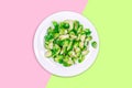 Lightly fried brussels sprouts on a white plate on the neon green and pink color drop Royalty Free Stock Photo