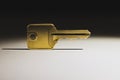 Lightly illuminated metal door key with a narrow shadow