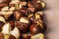 Lightly roasted edible chestnuts scattered on a wooden surface Royalty Free Stock Photo