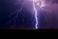 Lightning bolt strike during a storm with mountains in the background. Royalty Free Stock Photo