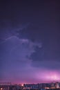 a lightning bolt strikes through the air above buildings in a city