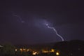 Lightning bolt striking the ground during a storm in Arizona. City lights are in the foreground. Royalty Free Stock Photo
