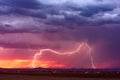 Lightning bolt at sunset with dark storm clouds Royalty Free Stock Photo