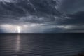 Lightning bolts reflection over the sea. taken during a thunderstorm over the ocean with clouds in the background Royalty Free Stock Photo