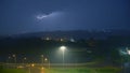 Lightning bolts in a storm at night over a city road Royalty Free Stock Photo